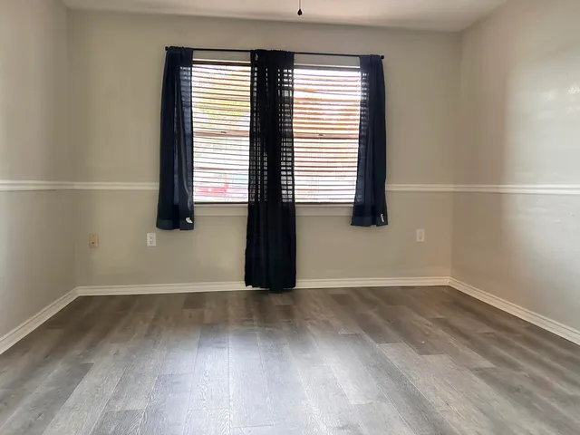 a view of a room with wooden floor and a window