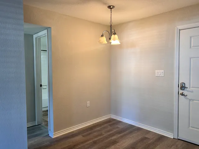 a view of a room with a wooden floor and a ceiling fan