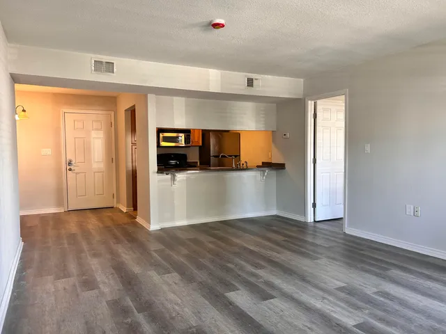a view of a kitchen with wooden floor and a sink