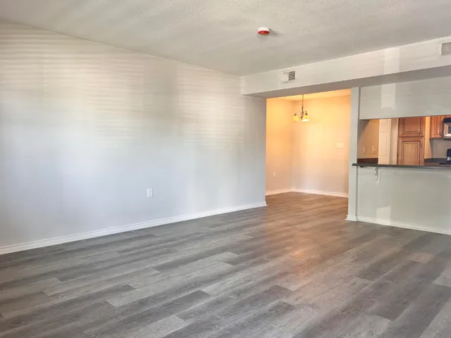 a view of a kitchen with wooden floor and a window
