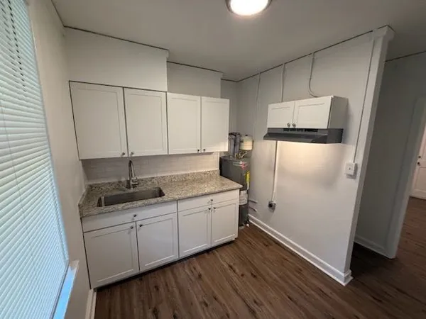 a kitchen with a sink a refrigerator and cabinets