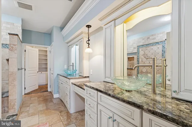 a spacious bathroom with a granite countertop sink mirror and a bathtub