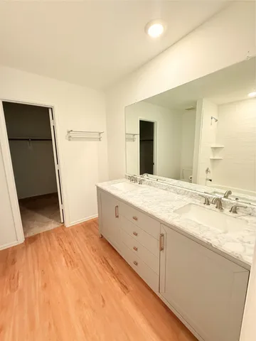 a spacious bathroom with a granite countertop sink a mirror and a bathtub