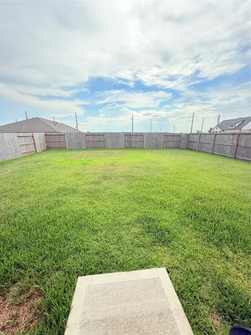 a view of a big yard with wooden fence