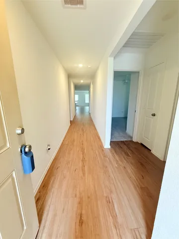 a view of a hallway with wooden floor and staircase