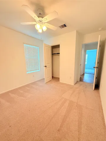 an empty room with fan and entryway