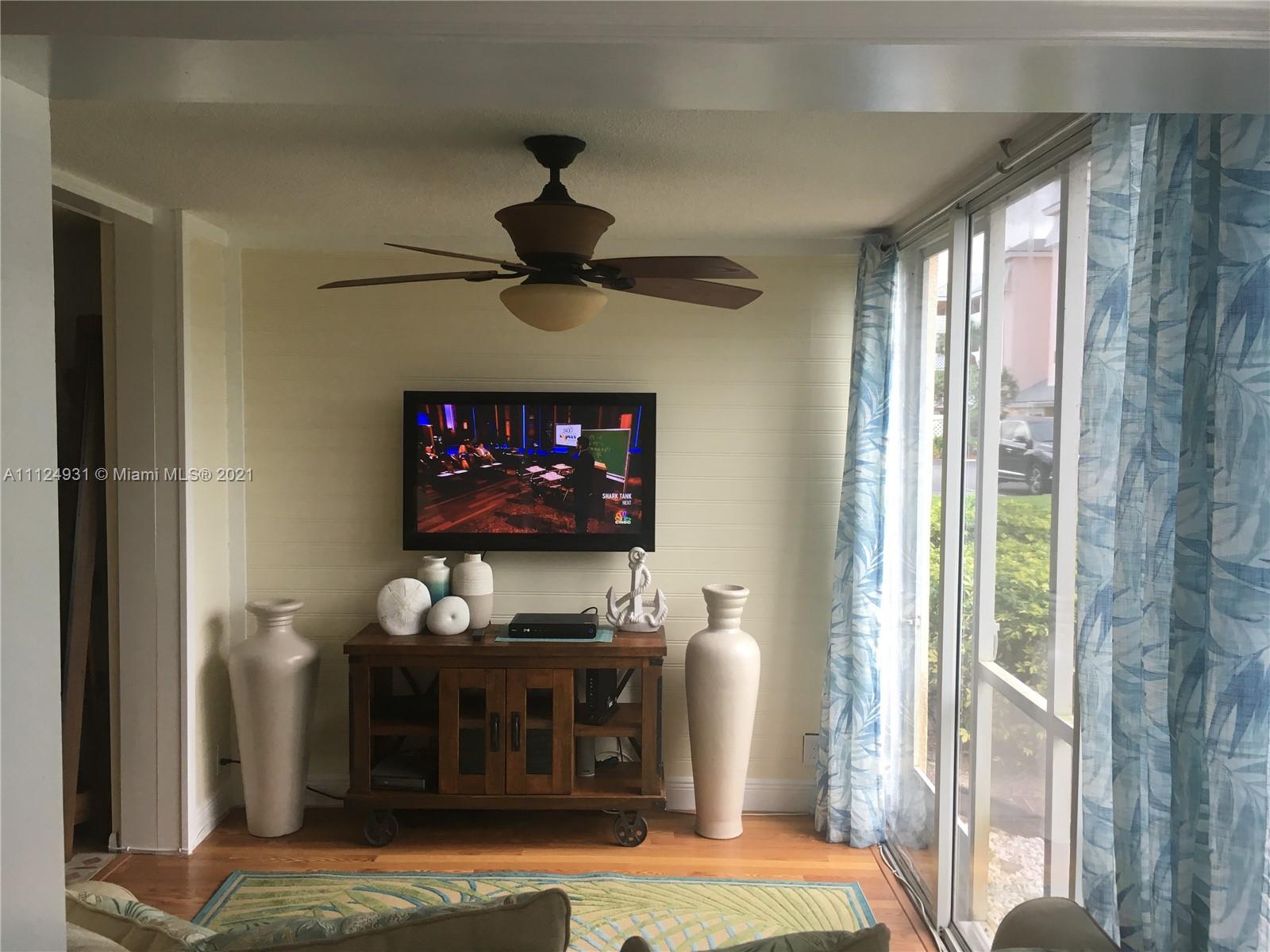 353 Highway 1, Unit D103 Jupiter, FL 33477 - Photo 3 of 11 a bedroom with furniture a flat screen tv and a fireplace