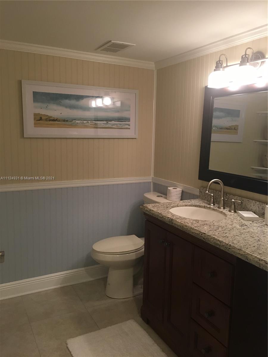 353 Highway 1, Unit D103 Jupiter, FL 33477 - Photo 7 of 11 a bathroom with a granite countertop sink toilet and mirror