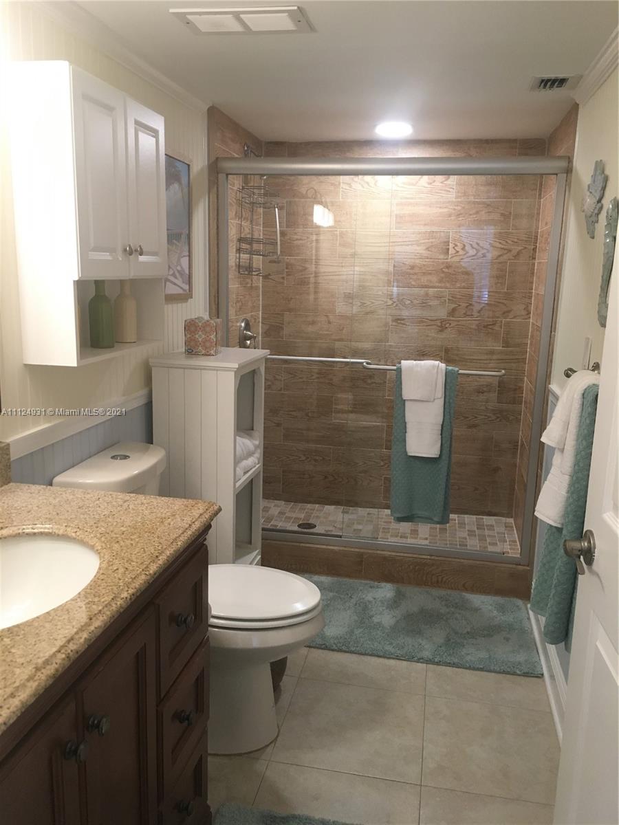 353 Highway 1, Unit D103 Jupiter, FL 33477 - Photo 8 of 11 a bathroom with a sink a toilet and shower