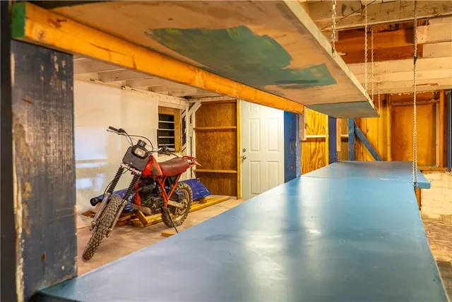 a view of swimming pool with lawn chairs and wooden fence