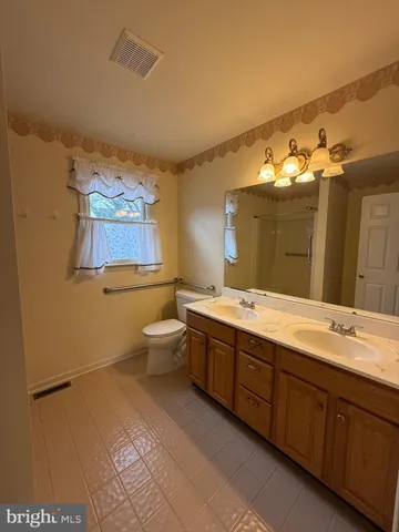a spacious bathroom with a granite countertop sink mirror and toilet