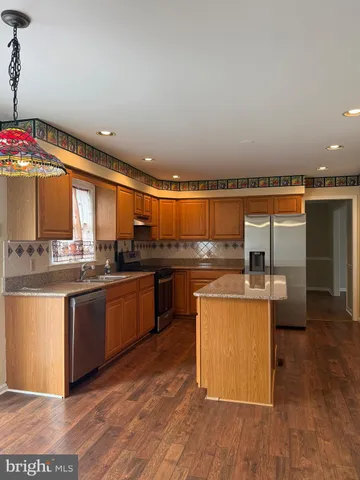 a kitchen with stainless steel appliances granite countertop a stove a sink and a refrigerator