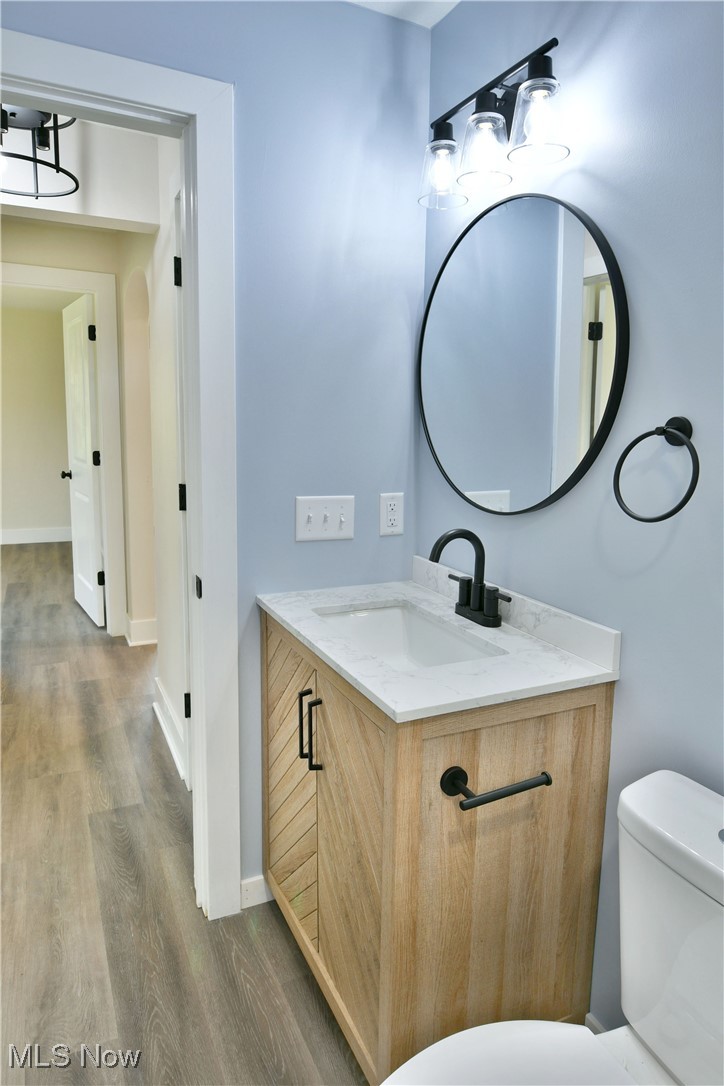 2096 Stillwagon Road Southeast Warren, OH 44484 - Photo 30 of 50 Bathroom featuring toilet, baseboards, wood finished floors, and vanity