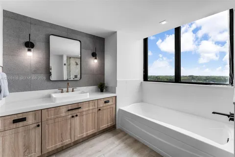 a bathroom with a tub a sink and mirror
