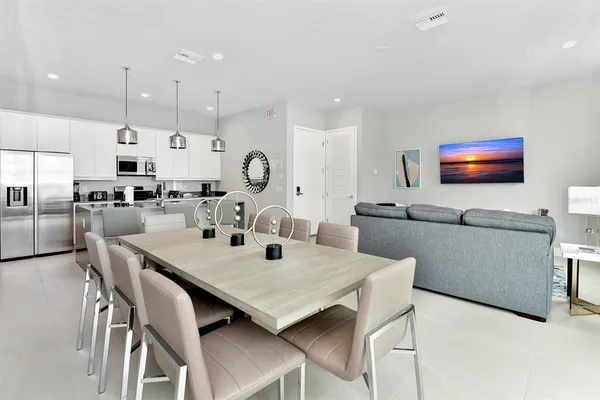 a kitchen with kitchen island stainless steel appliances a sink and living room view