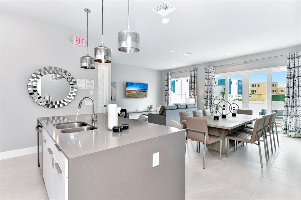 7770 Sandy Ridge Drive, Unit 135 Kissimmee, FL 34747 - Photo 28 of 43 a kitchen with kitchen island stainless steel appliances a table chairs in it and view living room