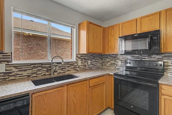 a kitchen with stainless steel appliances a stove sink and microwave