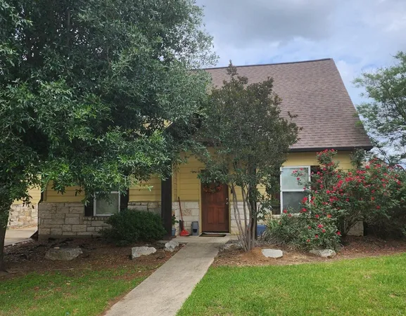 front view of a house with a yard and an trees