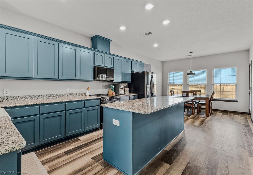a kitchen with stainless steel appliances granite countertop sink stove top oven and cabinets