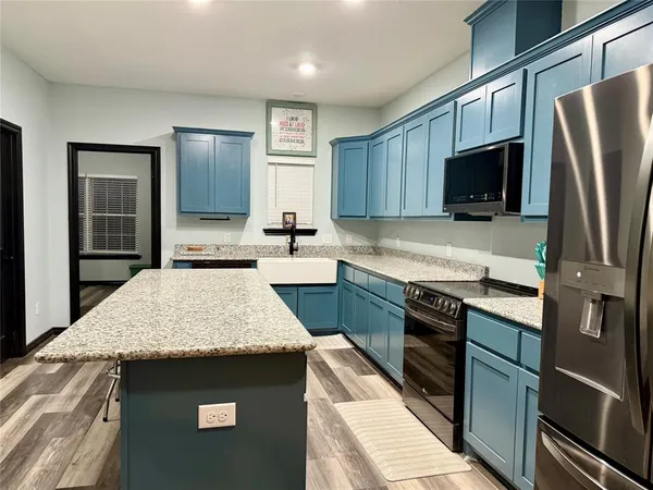 a kitchen with granite countertop a refrigerator stove and sink