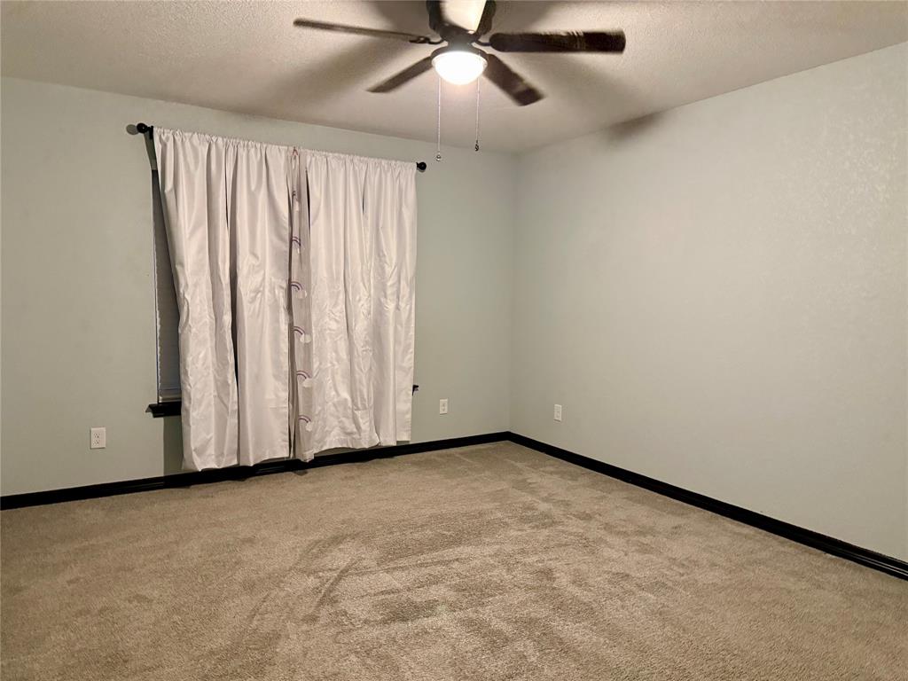 1384 County Road 1235 Point, TX 75472 - Photo 12 of 31 an empty room with a ceiling fan and a window
