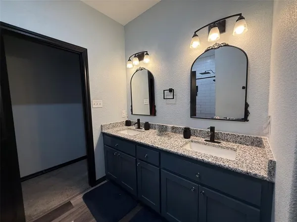 a bathroom with double vanity and a mirror