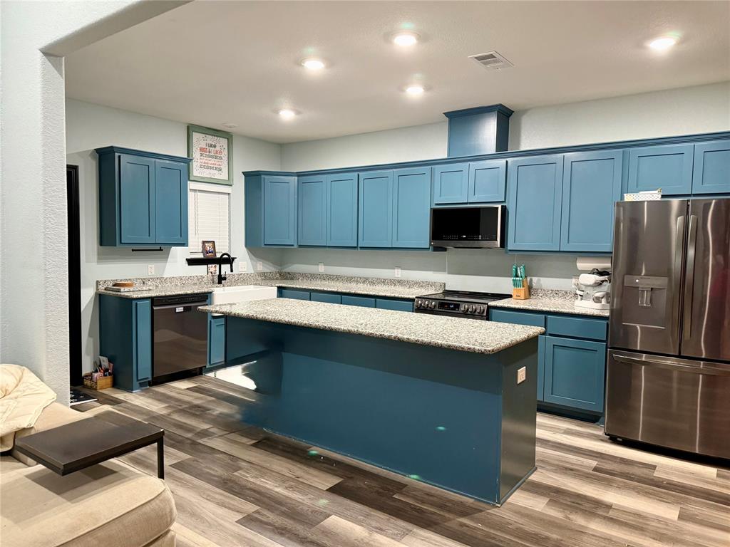 1384 County Road 1235 Point, TX 75472 - Photo 10 of 31 a kitchen with kitchen island a stove a refrigerator a sink and a oven with wooden floor