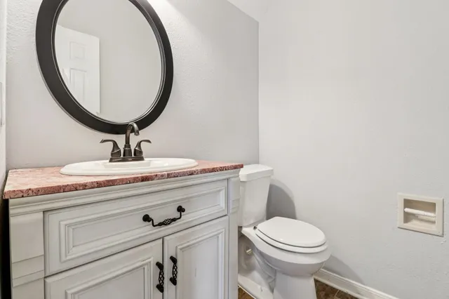 a bathroom with a toilet a sink and mirror