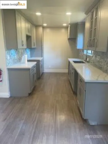 a large kitchen with stainless steel appliances a large counter top a stove a sink and a oven