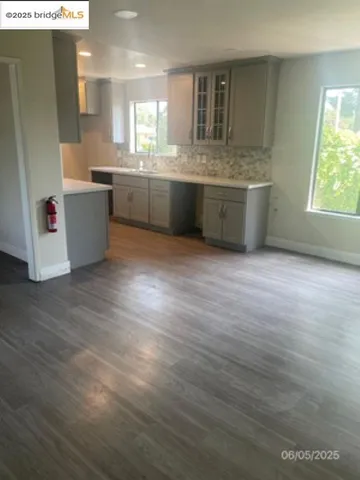 a room with kitchen island sink and wooden floor