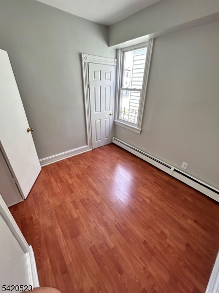 222 Inslee Place, Unit 2 Elizabeth Port, NJ 07206 - Photo 11 of 15 a view of an empty room with wooden floor and a window