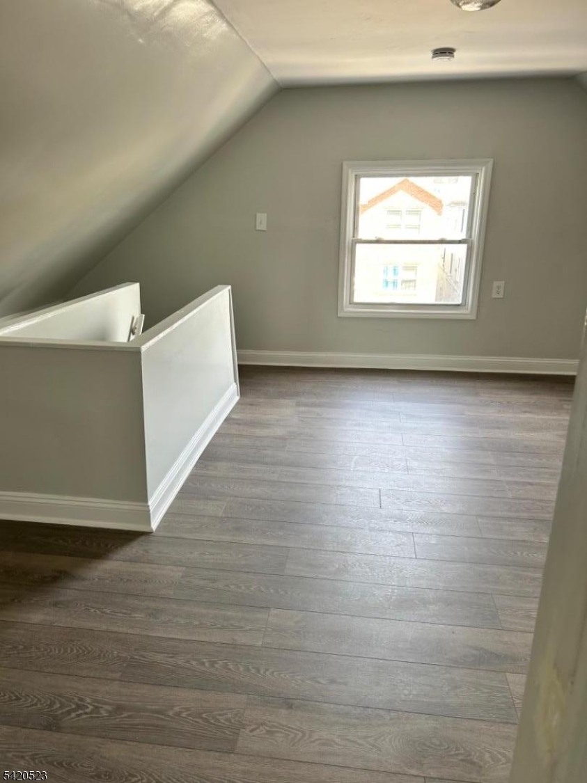 222 Inslee Place, Unit 2 Elizabeth Port, NJ 07206 - Photo 12 of 15 a view of an empty room with wooden floor and a window