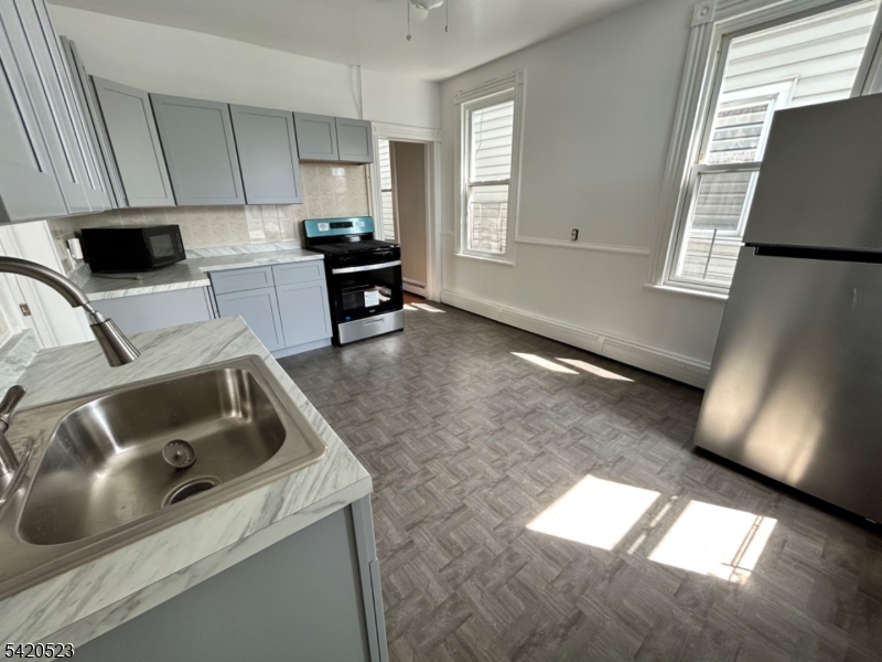 222 Inslee Place, Unit 2 Elizabeth Port, NJ 07206 - Photo 4 of 15 a kitchen with a sink cabinets and a window