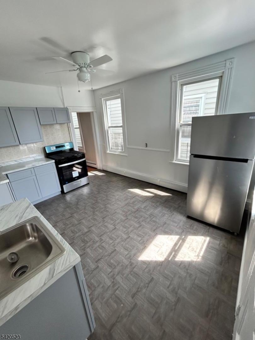 222 Inslee Place, Unit 2 Elizabeth Port, NJ 07206 - Photo 5 of 15 a kitchen with a refrigerator a stove a microwave and a window