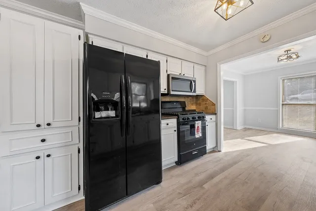 a kitchen with a refrigerator and a stove top oven