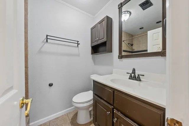a bathroom with a sink vanity granite toilet and a mirror