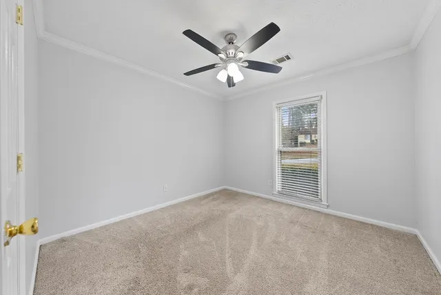 an empty room with windows and fan