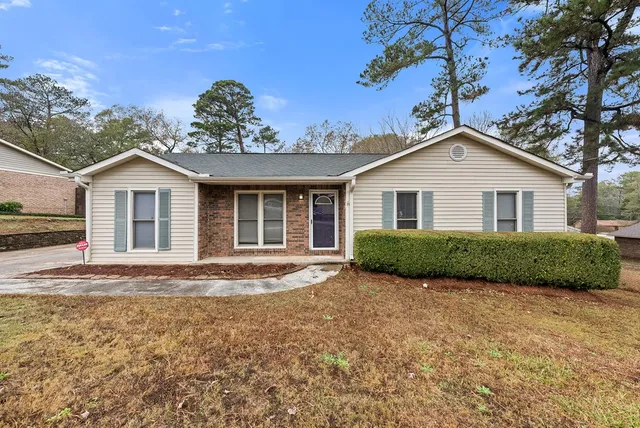 a view of a yard in front of a house with a large tree