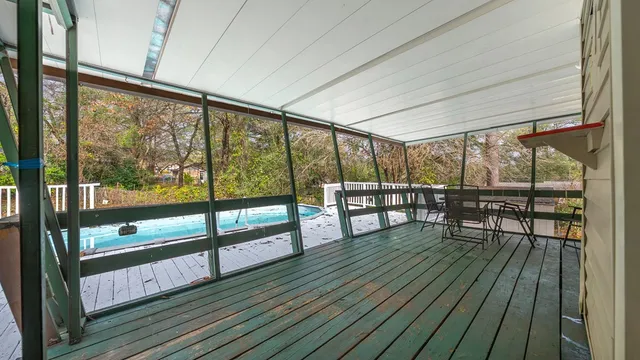 a view of a balcony with chairs and wooden floor