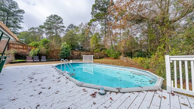 a view of a swimming pool with a patio and yard