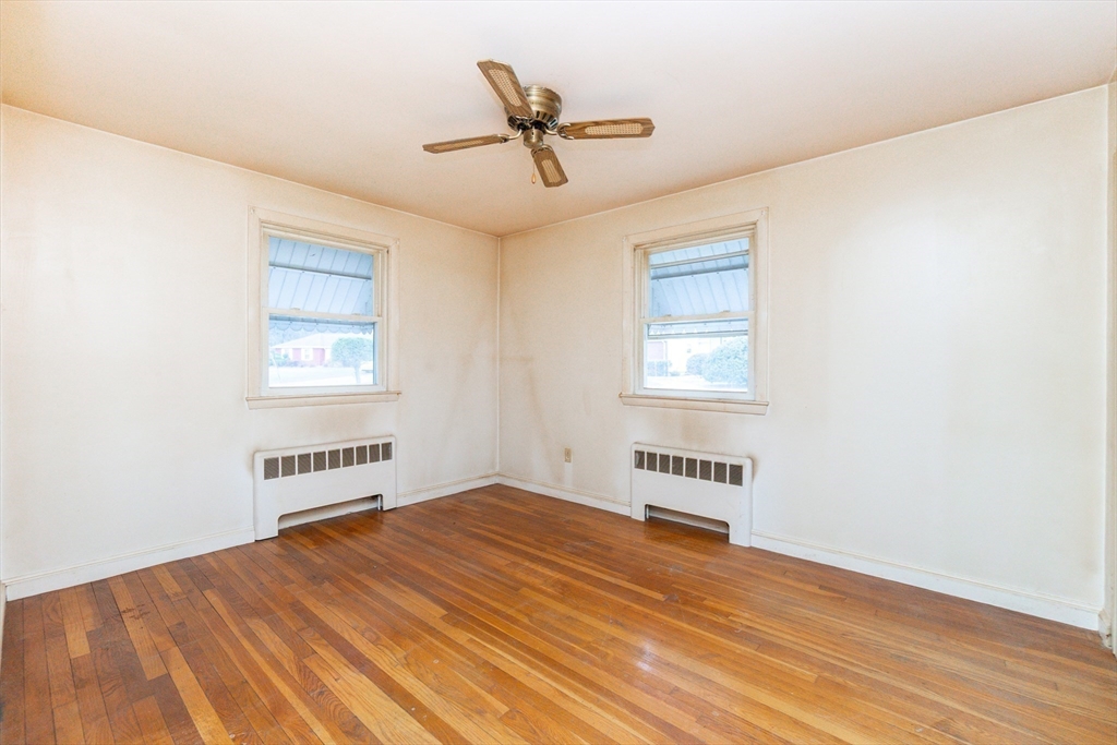 51 Pincushion Road Framingham, MA 01702 - Photo 12 of 42 an empty room with wooden floor ceiling fan and windows