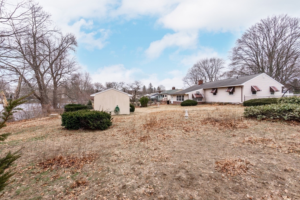 51 Pincushion Road Framingham, MA 01702 - Photo 31 of 42 a large white building with a big yard and large trees