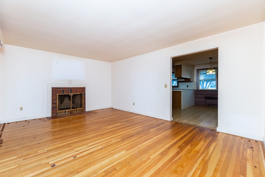 51 Pincushion Road Framingham, MA 01702 - Photo 9 of 42 a view of an empty room with a fireplace and a window
