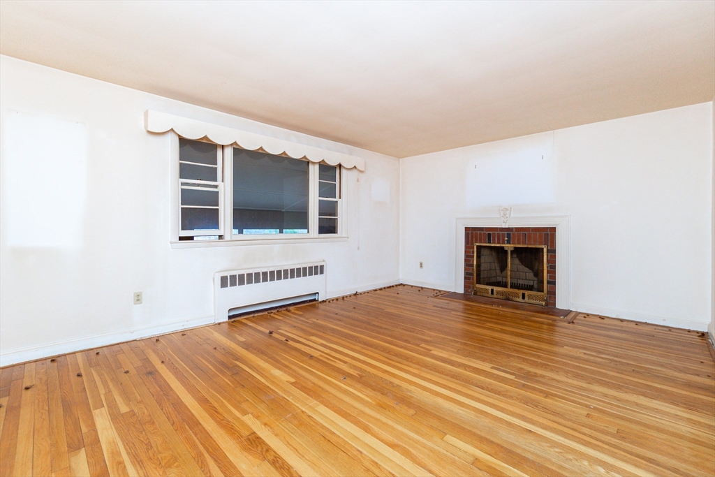 51 Pincushion Road Framingham, MA 01702 - Photo 10 of 42 a view of an empty room with a window and fireplace