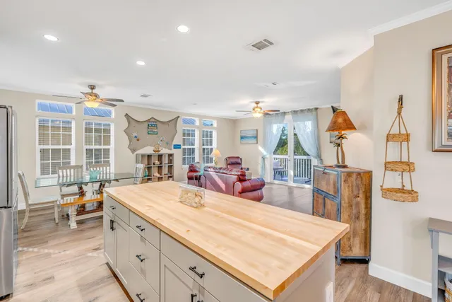 a large kitchen with sink a counter top space and living room view