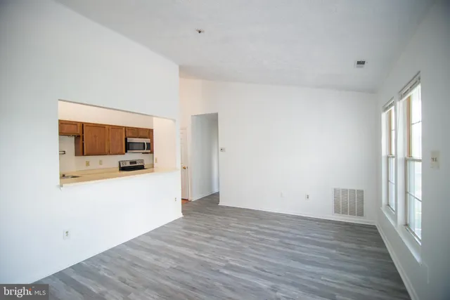 a view of a room with wooden floor and a flat screen tv
