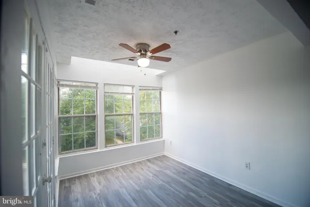a view of room with window ceiling fan and hardwood floor