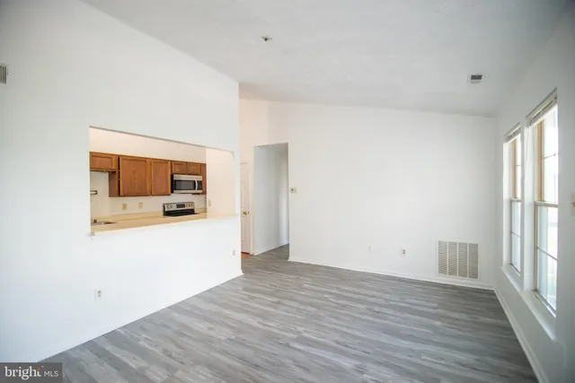 a view of a living room with hardwood floor and a window