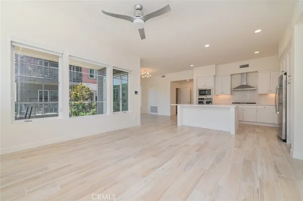 a view of a kitchen with wooden floor and electronic appliances