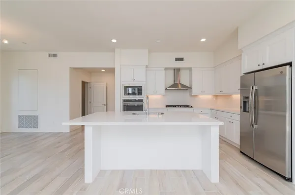 a kitchen with kitchen island a stove a refrigerator and a sink
